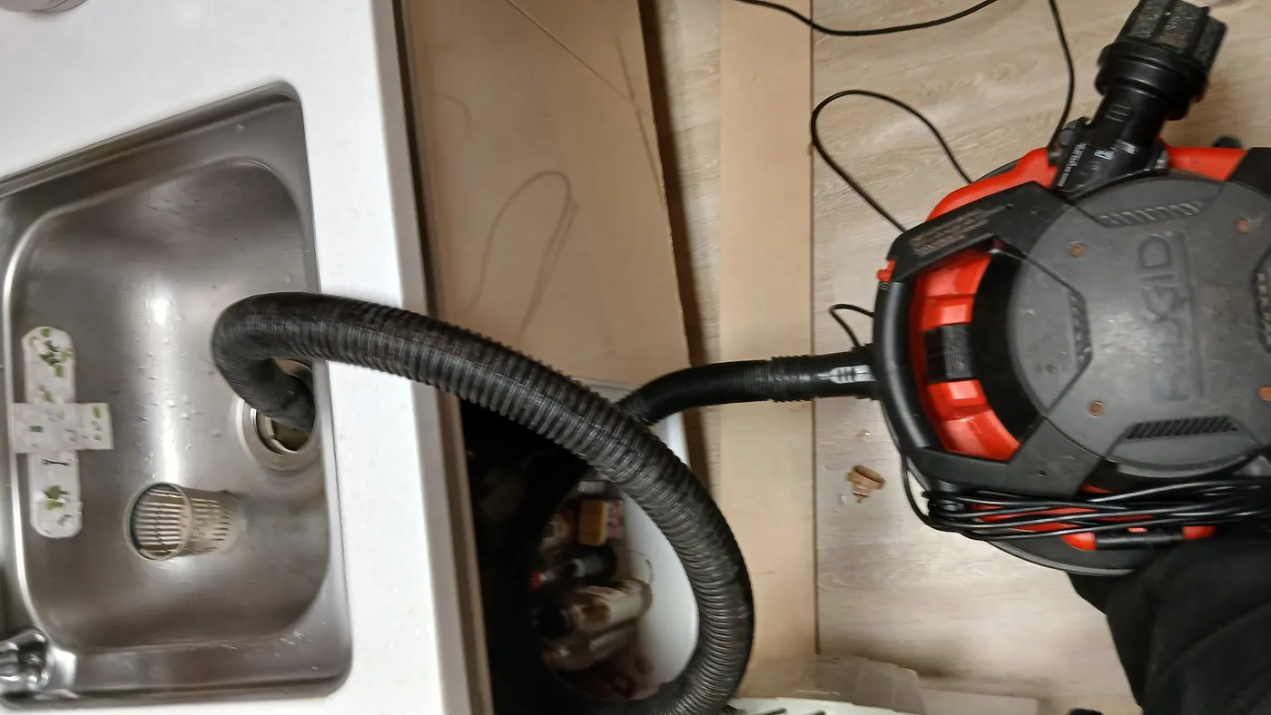 동두천시 지행동 아파트 싱크대 배수구에 RIDGID 건습식 진공 석션기의 석션 호스를 밀착시켜 흡입하는 모습