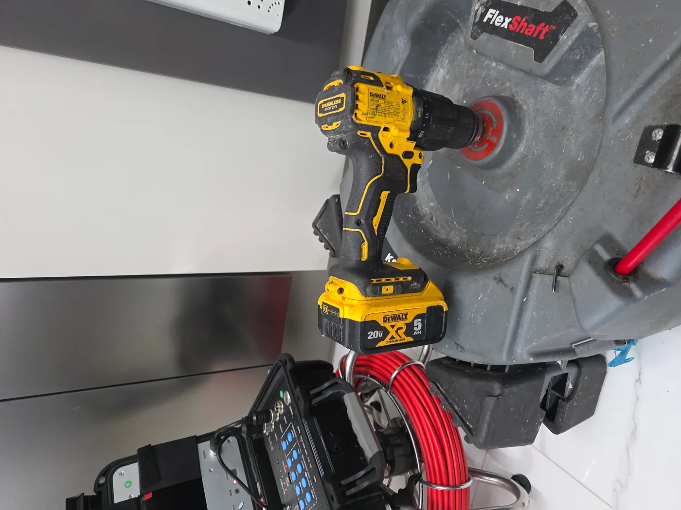 DeWalt 드릴을 물린 RIDGID 플렉스샤프트 드럼과 옆에 둔 배관 내시경 모니터