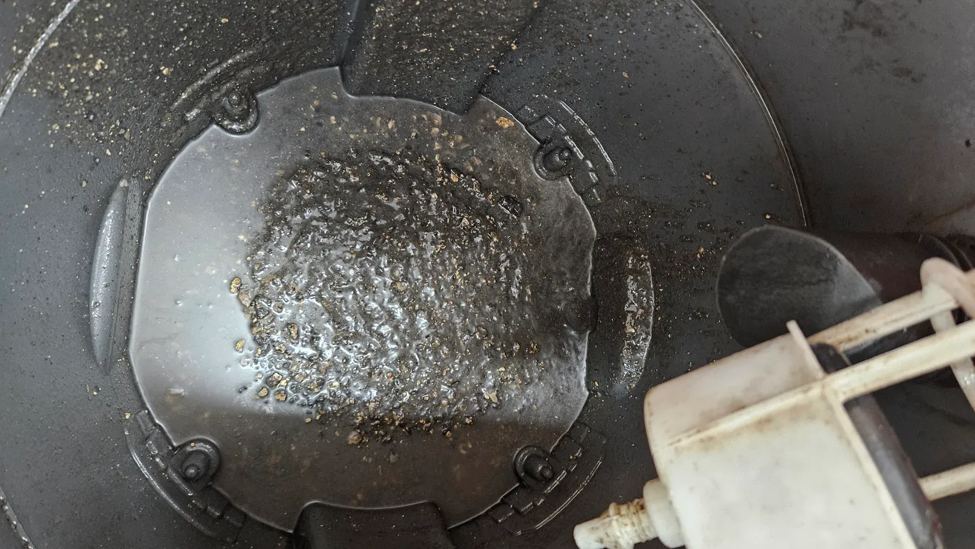 건습식 석션기 통 바닥에 배관에서 빨아낸 기름기 섞인 검은 물과 찌꺼기가 고인 모습