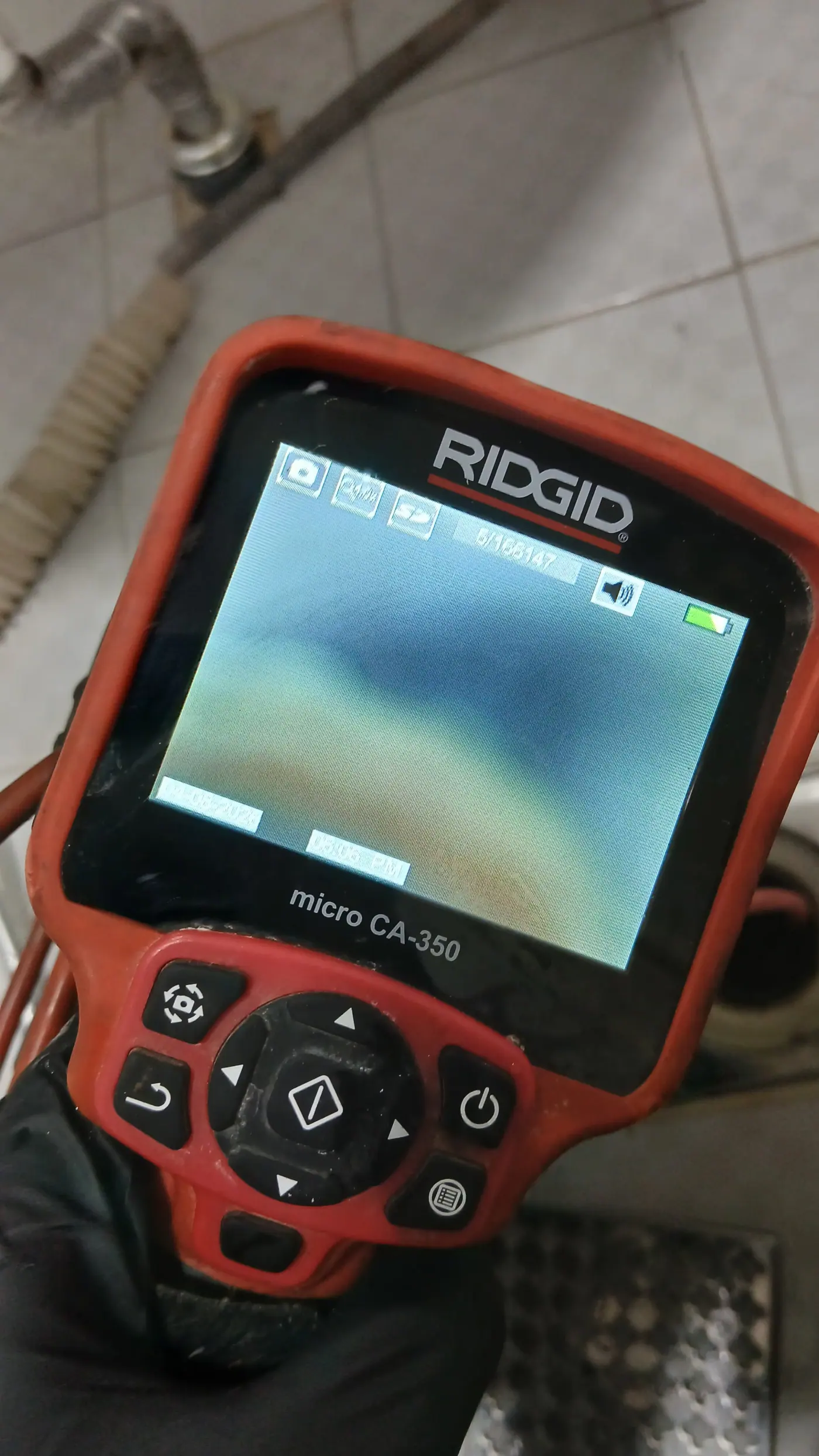 RIDGID 내시경 모니터 화면으로 배관 내부를 점검하는 모습